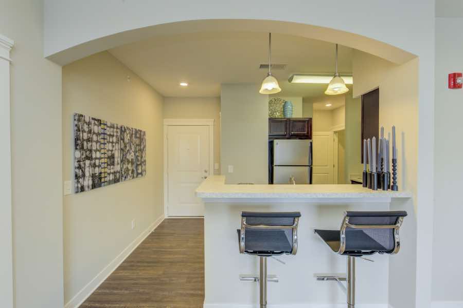 Any area like this kitchen at Highpointe on Meridian Apartments can be designed using feng shui principles. Kitchen and entryway of an apartment with bar counter, hanging lights, and archway.