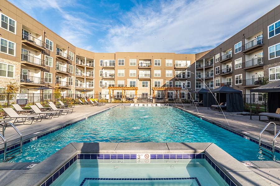 Amenities like this swimming pool at The Verge Luxury Flats in Greenwood will play a key role in where you decide to live. Apartment swimming pool with fountains and lounge chairs.