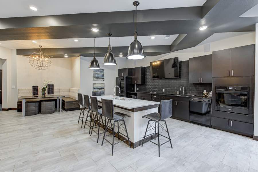 New apartment communities feature upscale amenities like this clubhouse kitchen at Midtown Flats in Carmel. Kitchen area in modern apartment clubhouse.