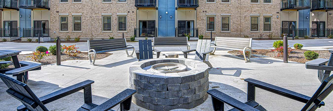 Exterior view of East Bank Apartments in Noblesville with seating and a fire pit