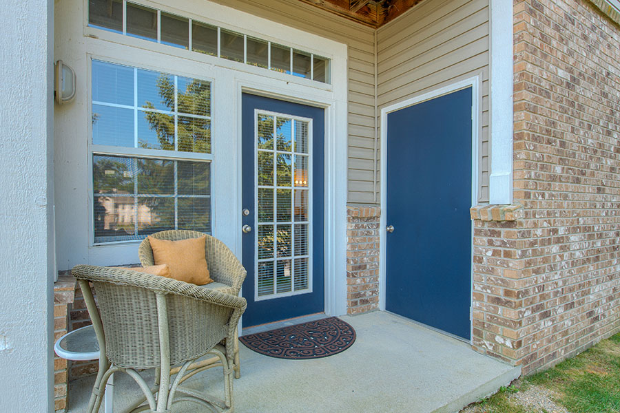 When you have a lovely entryway like this one at Bayshore Apartments, all you need to add is an inviting doormat. Welcoming mat and set of wicker chairs on a front porch of an apartment entryway located at Bayshore Apartments.