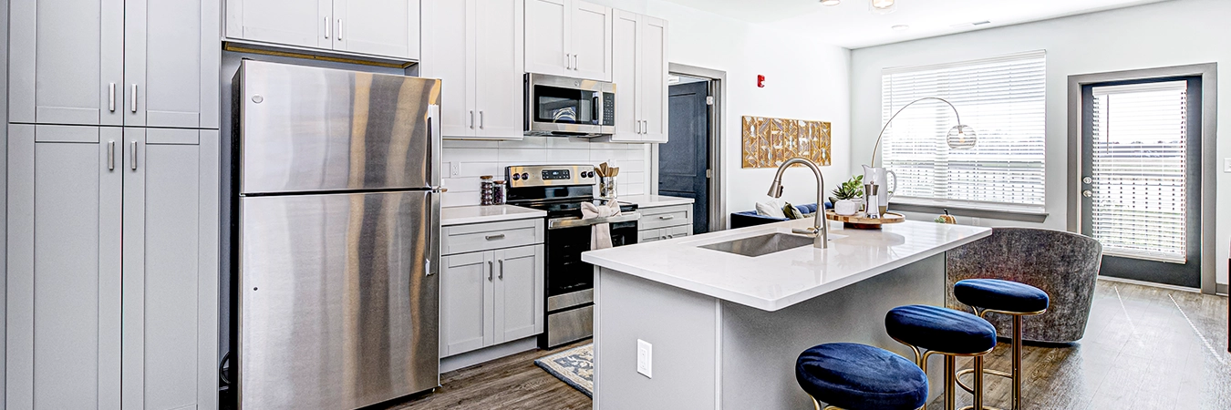 View of spacious apartment kitchen with island seating