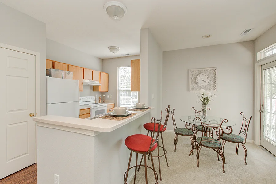 Lights out? Find a flashlight and uncover your windows like these in an Ashley Place apartment. A kitchen and dining room with uncovered windows in an Ashley Place Apartments apartment