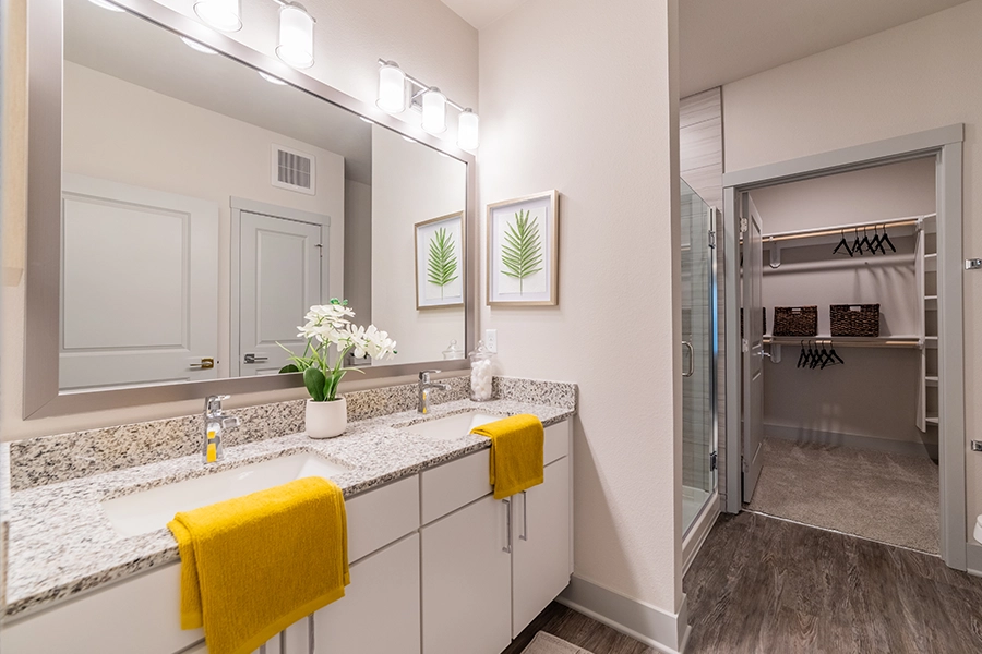 This spacious bathroom connected to a walk-in closet at Verge Luxury Flats may be the type of apartment floor plan you need. Bathroom with dual sinks connected to a walk-in closet