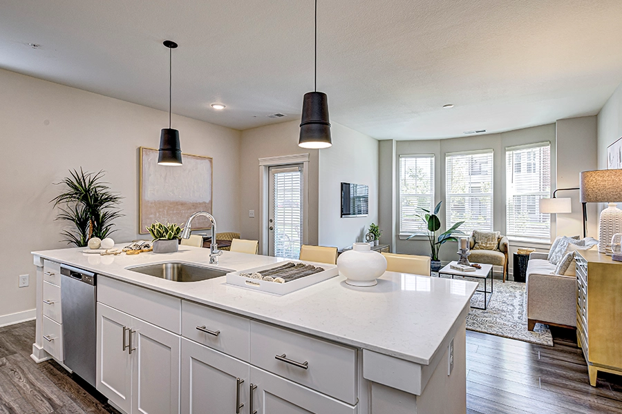 Many residents look for open floor plans with built-in storage, like the unit seen here at Wheelhouse Apartments on the Monon. Kitchen island in an upscale apartment with main living area in the background